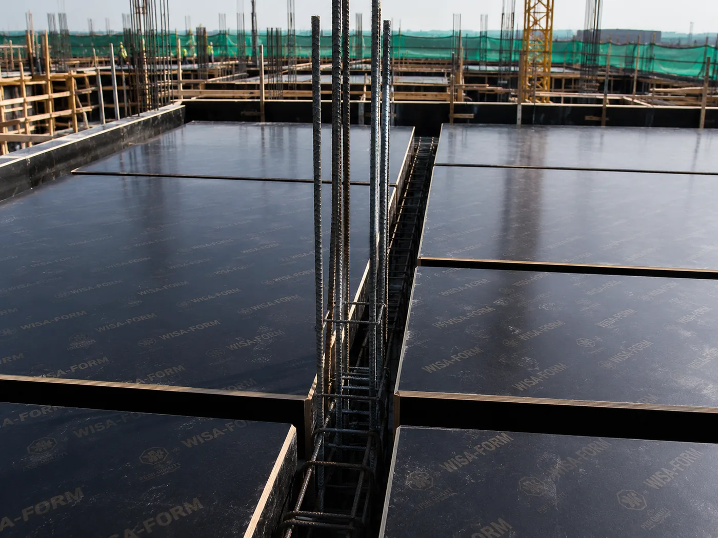 Black formwork panels installed on an active construction site